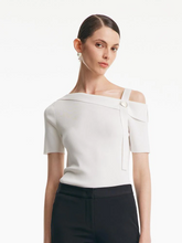 a lady in white acetate one shoulder knit top
